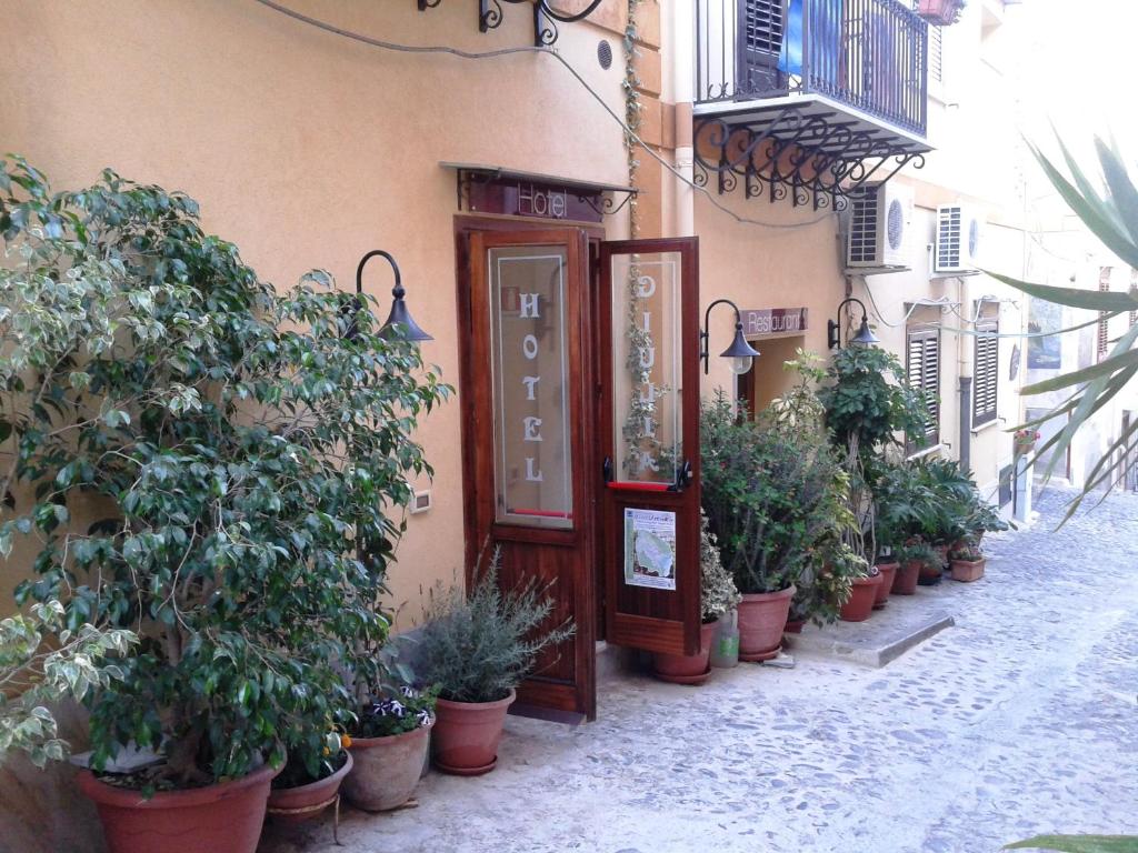 eine Reihe von Topfpflanzen vor einem Gebäude in der Unterkunft Hotel Giulia in Ustica