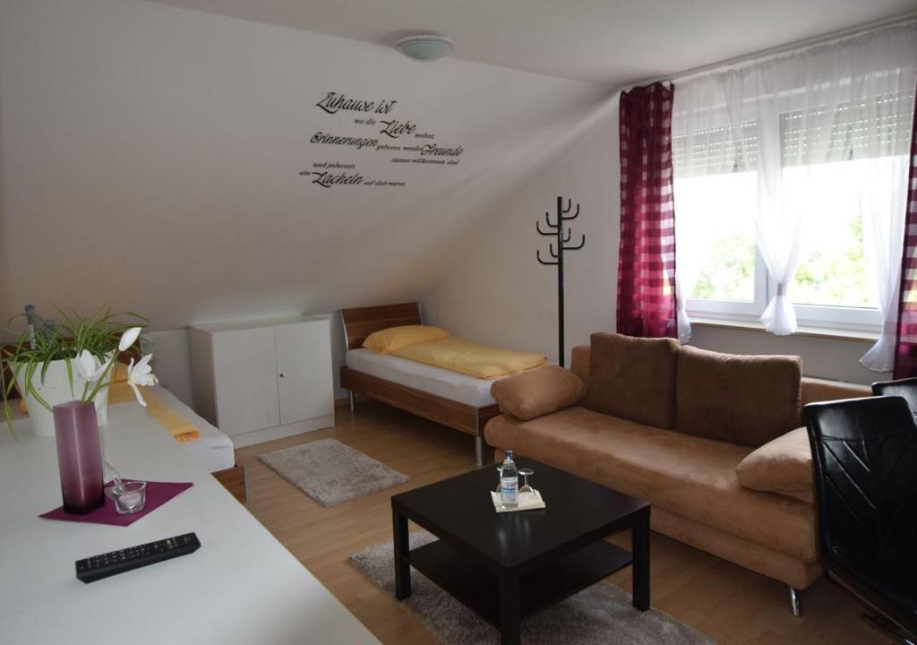 ein Wohnzimmer mit einem Sofa und einem Tisch in der Unterkunft Apartment Hotel Alena in Filderstadt