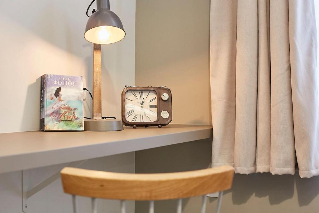 stół z zegarem, książką i lampą w obiekcie Enjoy Athens from a funky studio near Acropolis! w Atenach