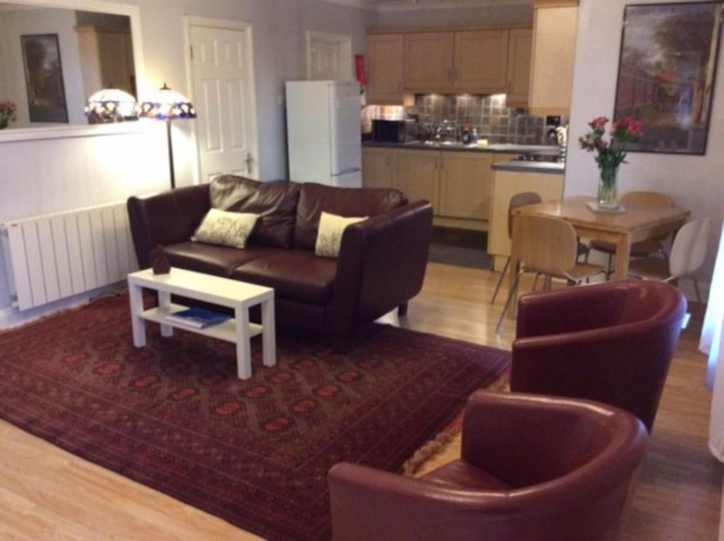 een woonkamer met een bank, stoelen en een tafel bij Stansted spacious 2-bed apartment, easy access to Stansted Airport & London in Stansted Mountfitchet