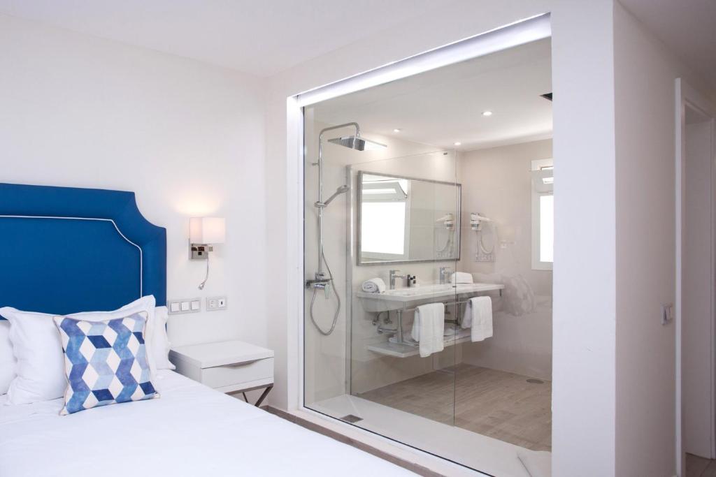 a bedroom with a shower and a bed and a sink at Hotel Boutique TAO Caleta Mar in Corralejo