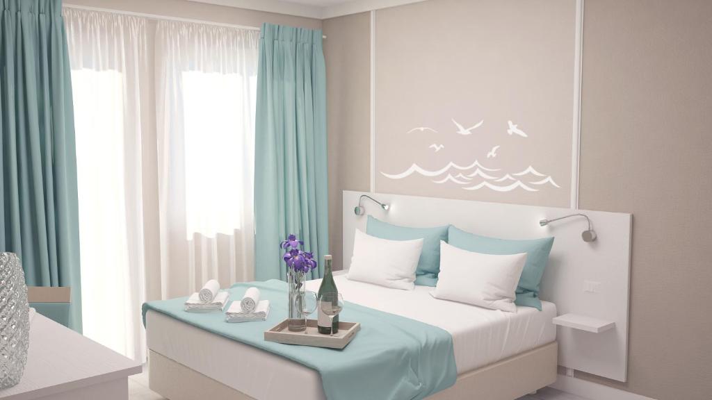 Dormitorio blanco y azul con cama y ventana en La Smeralda - Boutique Rooms and Breakfast en Golfo Aranci
