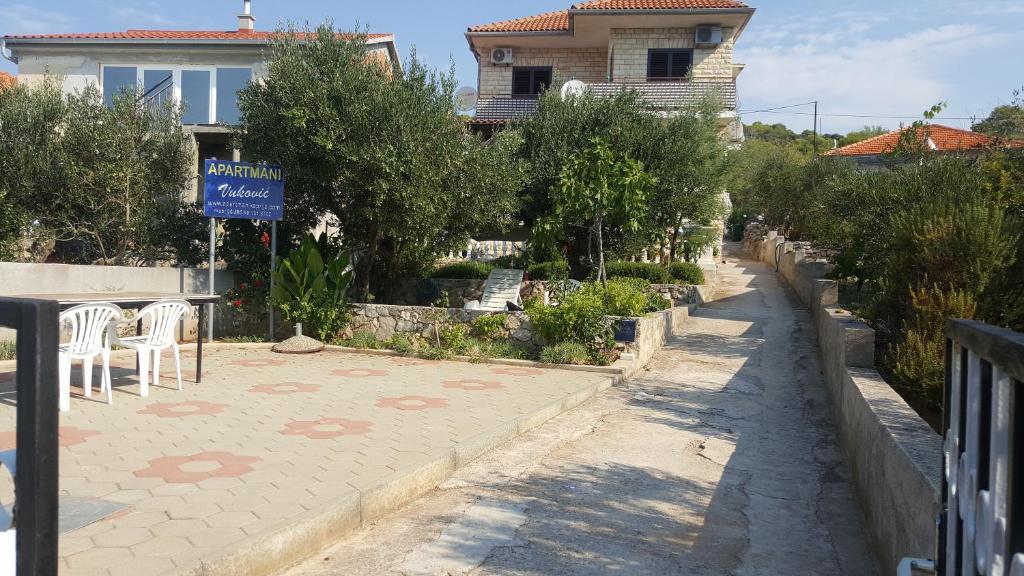 a street with a table and chairs and a house at Apartmani Vuković in Kaprije