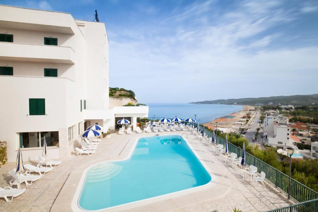 a view of a hotel with a swimming pool and the ocean at Svevo Sea House in Vieste