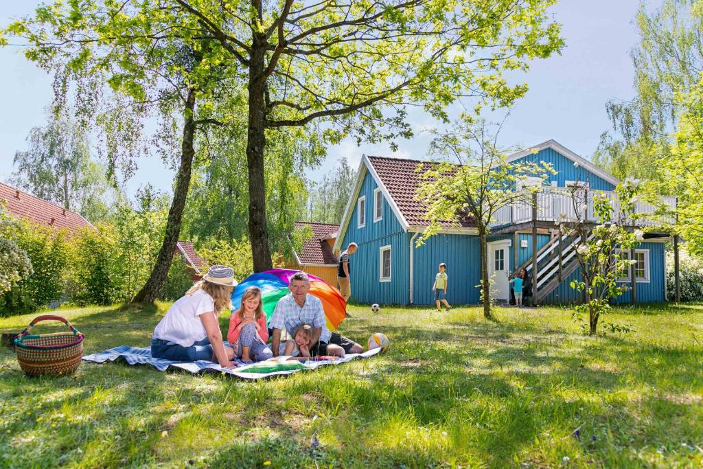 Eine Gruppe von Menschen, die auf einer Decke im Gras sitzen in der Unterkunft Müritzparadies in Boek