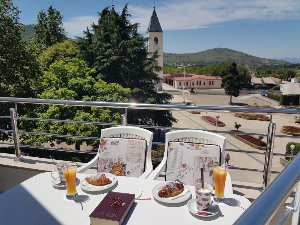 a table with food and drinks on a balcony at Gloria Apartments 2 in Međugorje