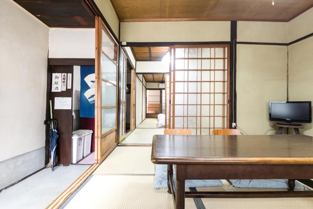 a dining room with a table and a television at Kyomachiya Real Kyoto Wabisabi in Kyoto