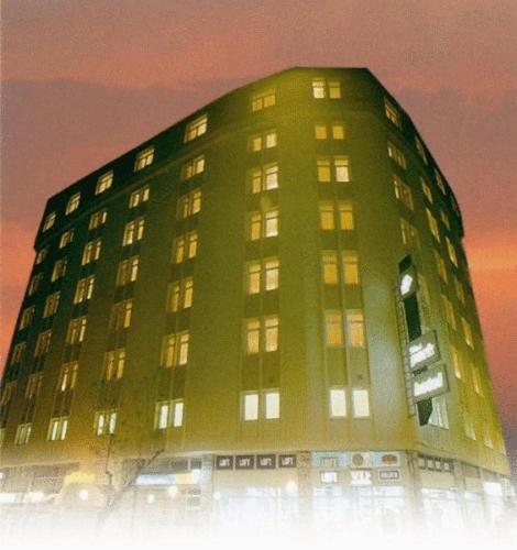 a tall green building with its lights on at Silivri Park Hotel in Silivri