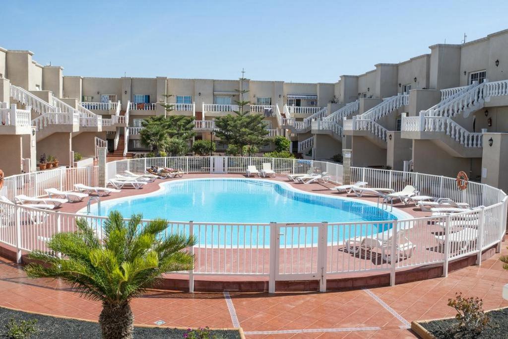 una imagen de una piscina en un complejo en Las Arenas caleta de fuste en Caleta de Fuste