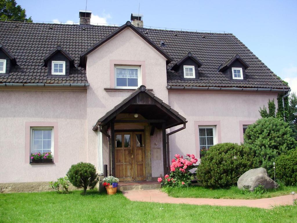 a house with a brown door and flowers in the yard at Ubytování Doma in Tisá