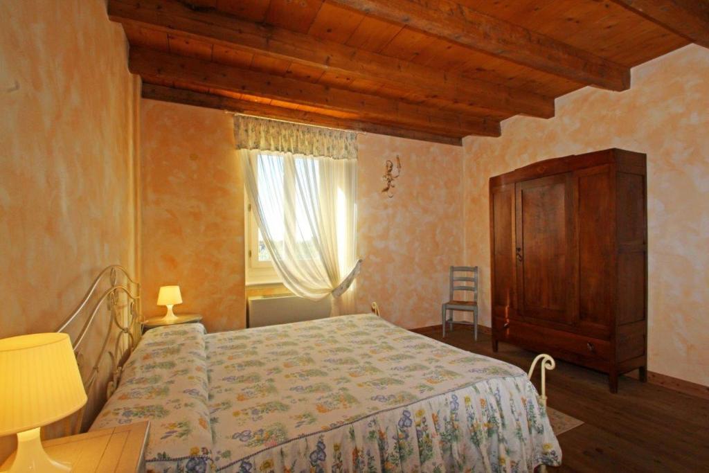 una camera con letto, cassettiera e finestra di Cascina Le Preseglie a Desenzano del Garda