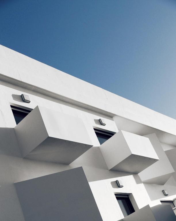 a white building with windows and a blue sky at Le Grand Hotel de la Plage in Biscarrosse-Plage