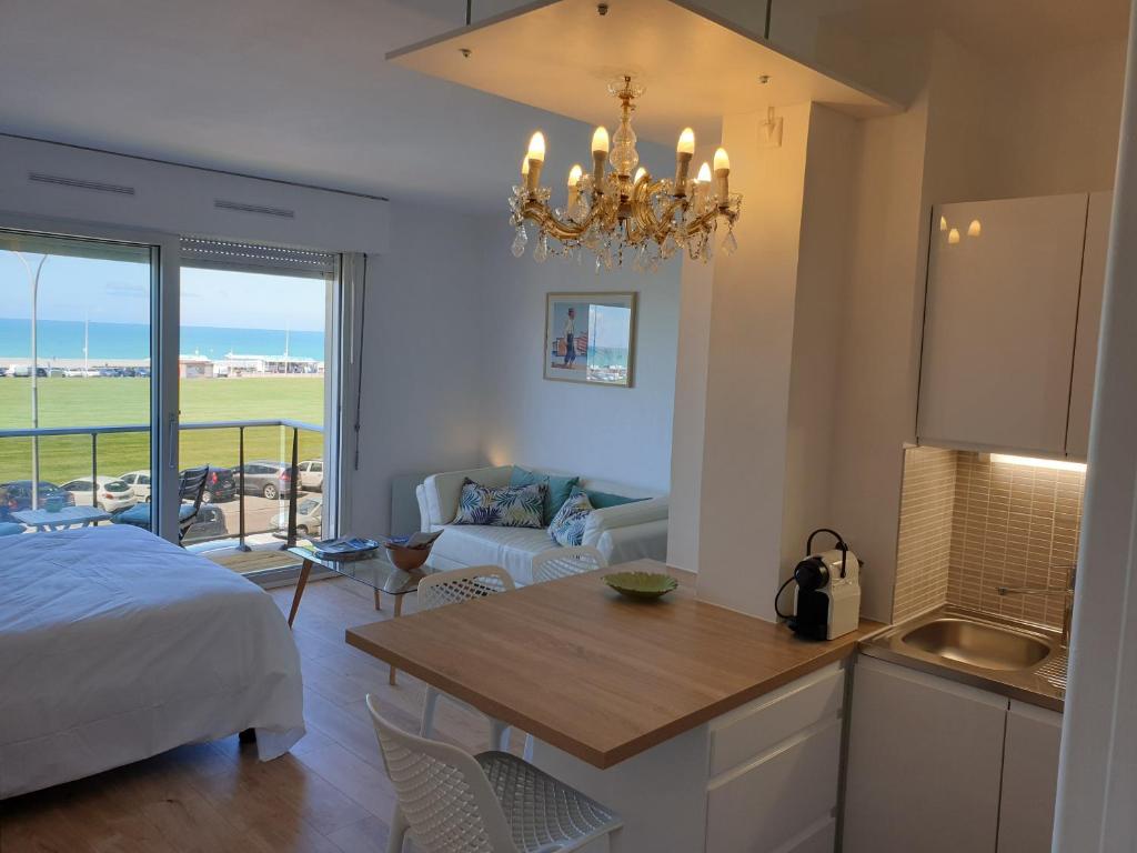 1 dormitorio con 1 cama y cocina con mesa en L'Albâtre en Dieppe