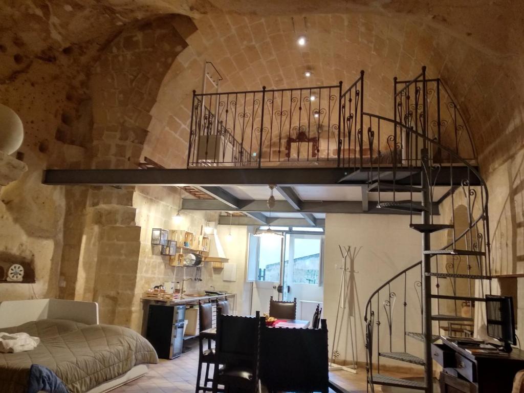 馬泰拉的住宿－Casa Masiello La casa tipica dei Sassi di Matera，一间石墙内有螺旋楼梯的房间