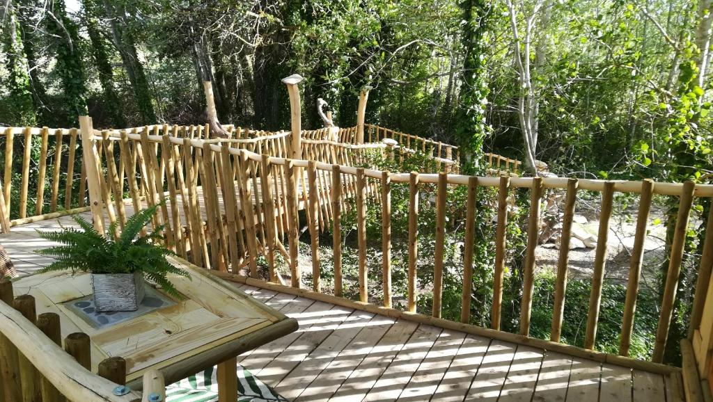 a wooden fence with a wooden table and a bench at LA CABANE PERCHEE in Villelaure