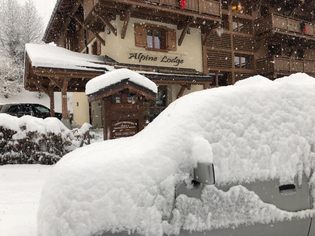 a car covered in snow in front of a lodge at Alpine Lodge 5 in Les Contamines-Montjoie
