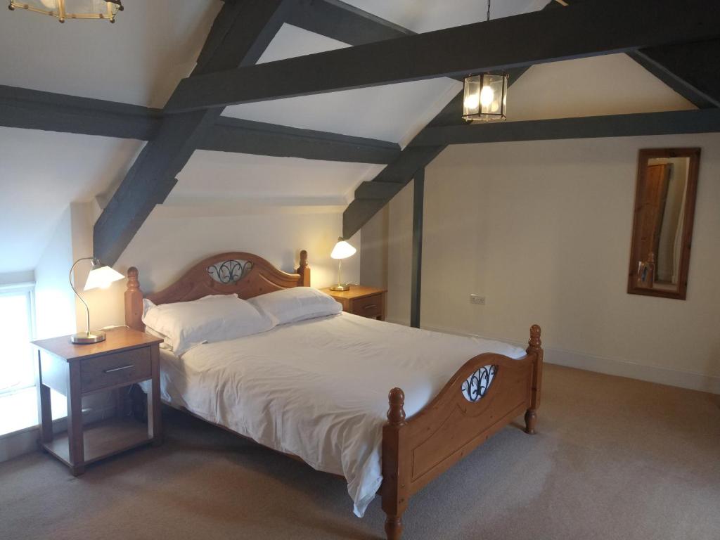 a bedroom with a large bed with a wooden headboard at Castle Square Apartments Beaumaris in Beaumaris