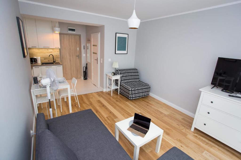 CR Wygodny Apartament w Centrum Nowy Świat 13 في بياويستوك: غرفة معيشة بها أريكة وطاولة