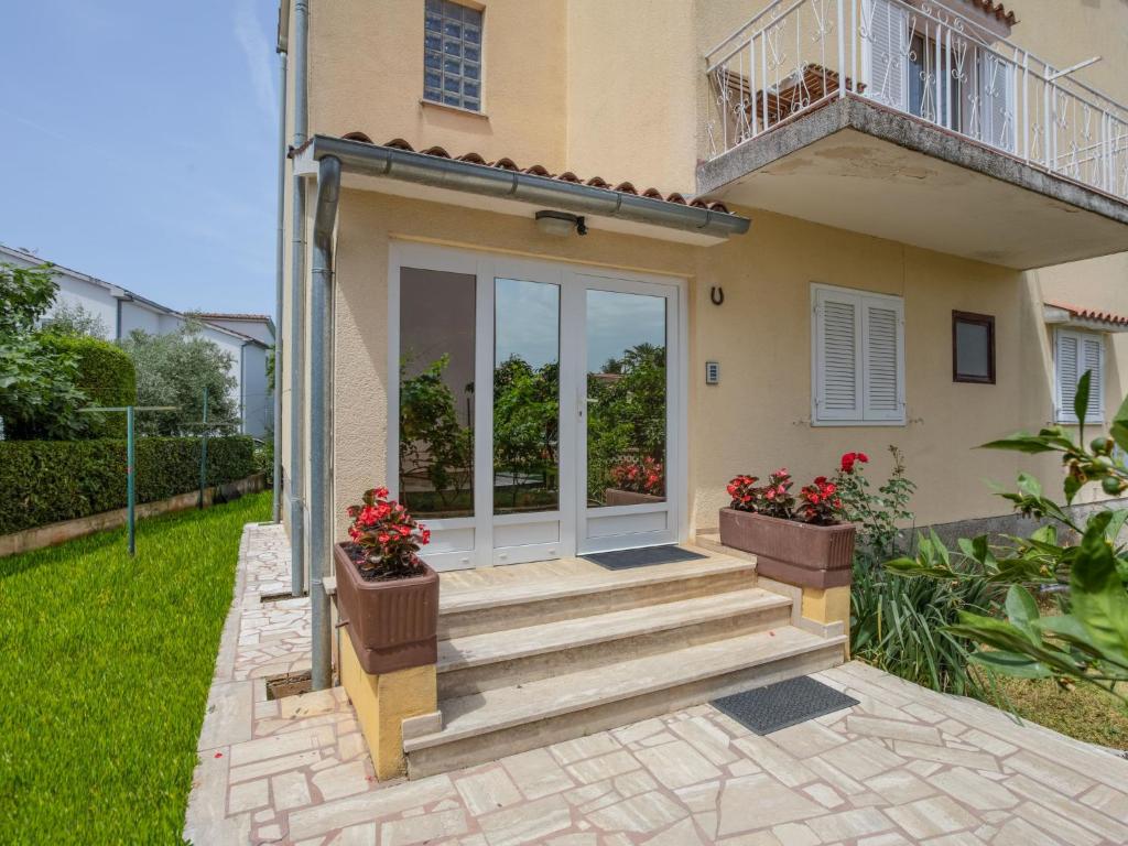 une porte d'entrée d'une maison ornée de fleurs en pot dans l'établissement Apartment Daria-1 by Interhome, à Poreč