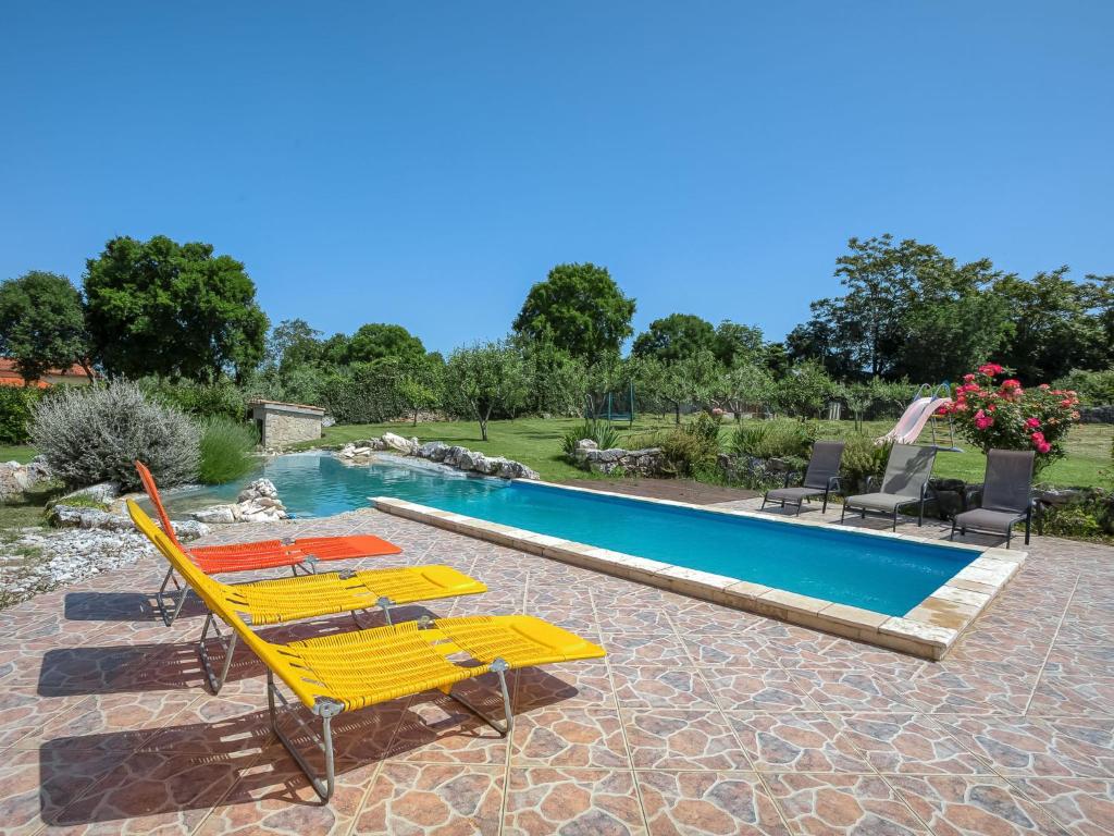 a group of yellow lounge chairs and a swimming pool at Holiday Home Mario 1 by Interhome in Hreljići