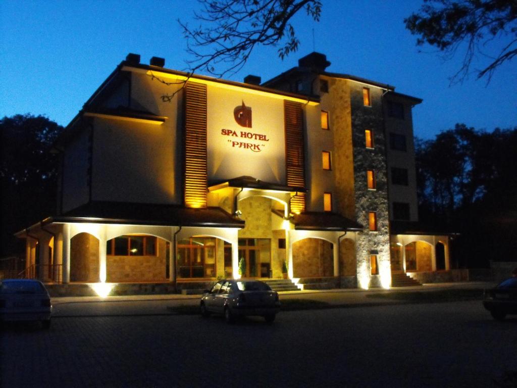 a building with a car parked in front of it at Hotel Park in Karnobat