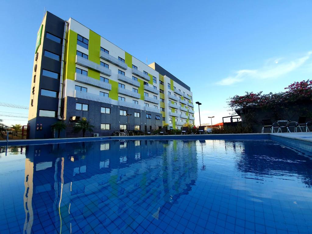 un hotel con piscina frente a un edificio en ibis Styles Parauapebas en Parauapebas