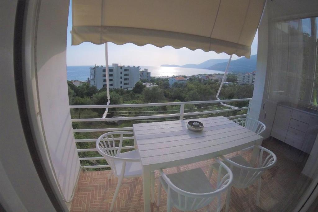 - Balcón con mesa blanca y sillas en Villa Goxhi, en Borsh