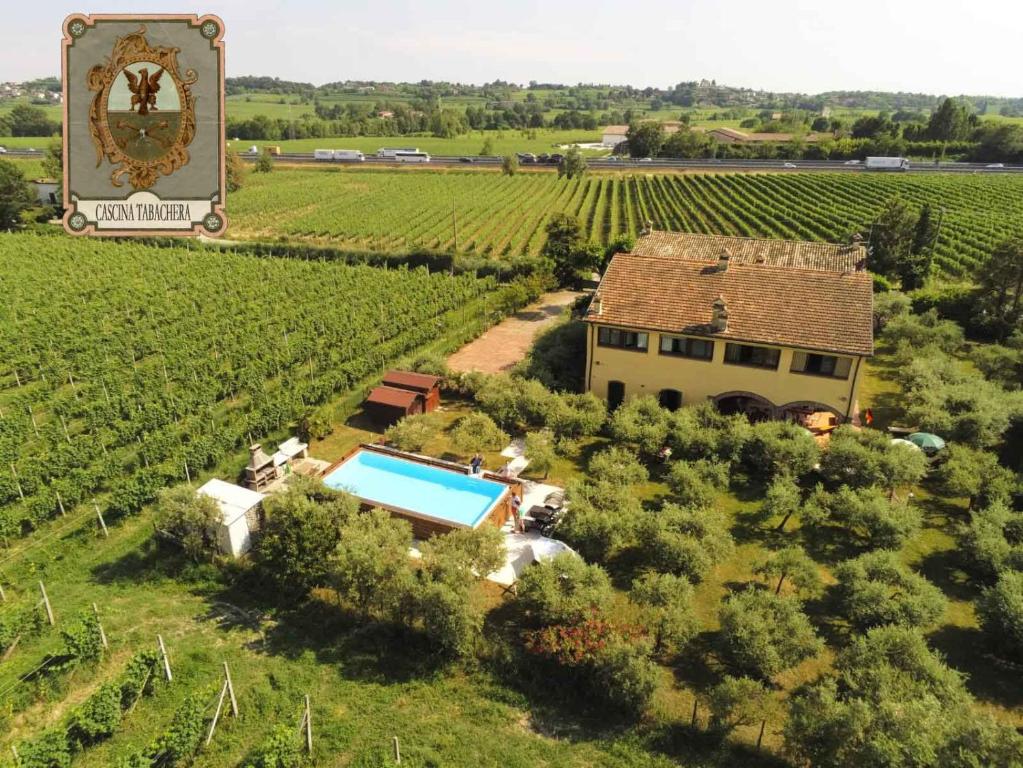 an aerial view of a vineyard with a house and a swimming pool at CASCINA TABACHERA x10 Vineyard House - GARDA LAKE in Pozzolengo