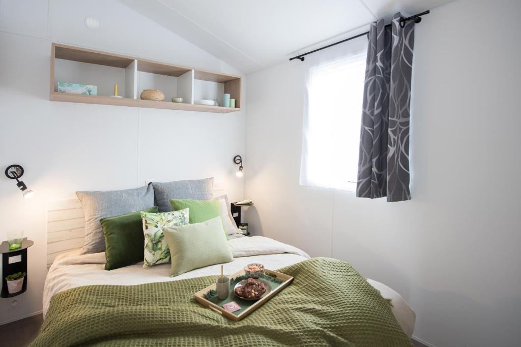 a bedroom with a bed with a tray on it at Camping l'Ile aux Oiseaux in LʼÎle-dʼOlonne