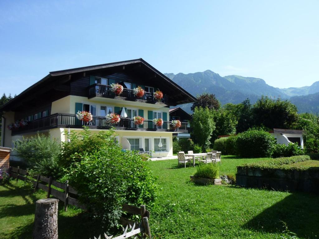 a house with flowers on the balconies in a yard at Oberstdorfer Ferienwelt in Oberstdorf
