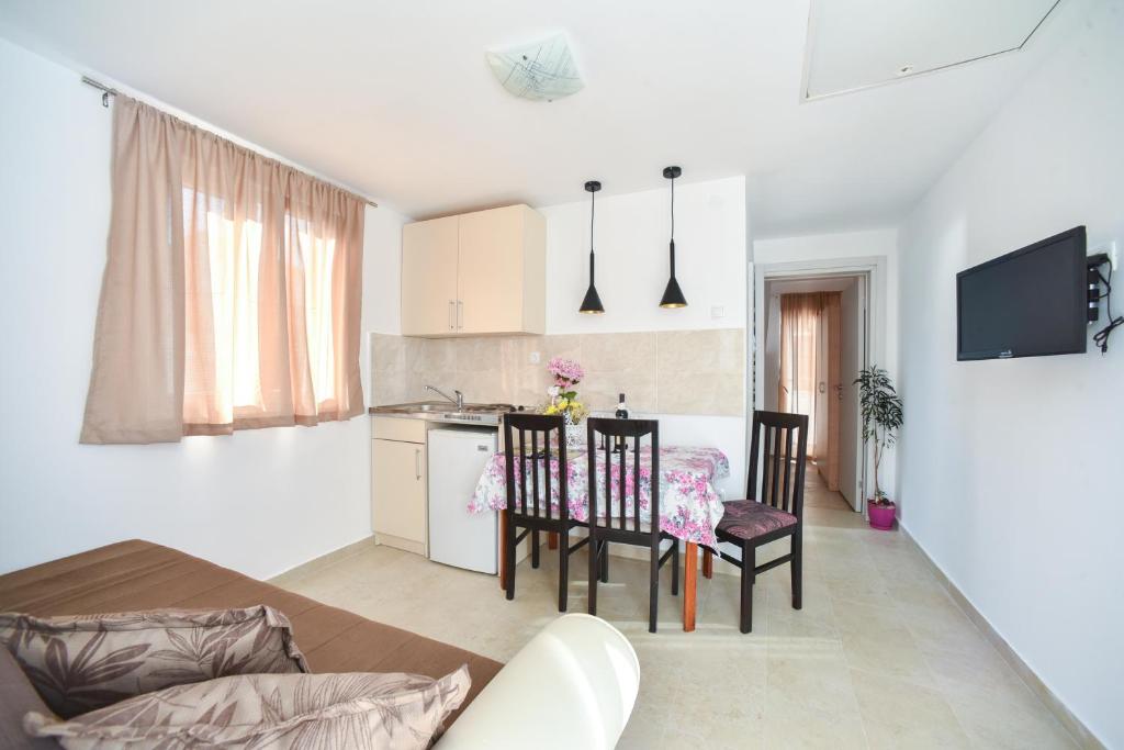 eine Küche und ein Esszimmer mit einem Tisch und Stühlen in der Unterkunft Apartmani Bonik in Budva