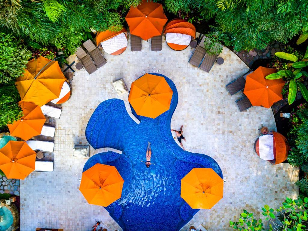 an overhead view of a pool with umbrellas and tables at Nayara Gardens in Fortuna