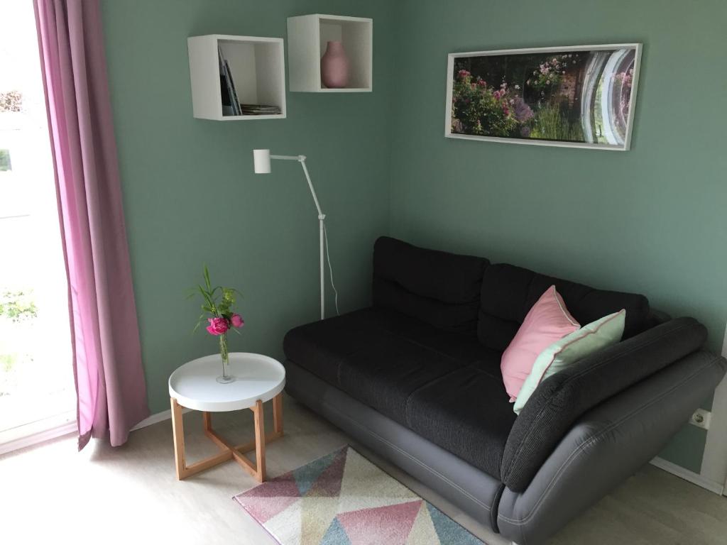 sala de estar con sofá negro y mesa en Apartment Kirschti, en Salzwedel