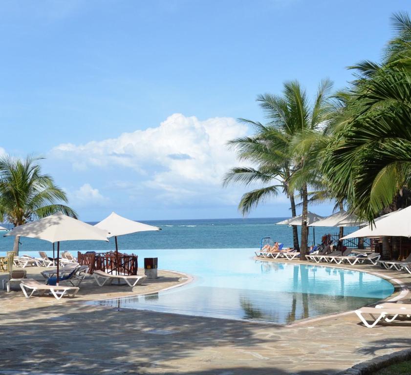 
a beach filled with palm trees and palm trees at Baobab Beach Resort & Spa in Diani Beach
