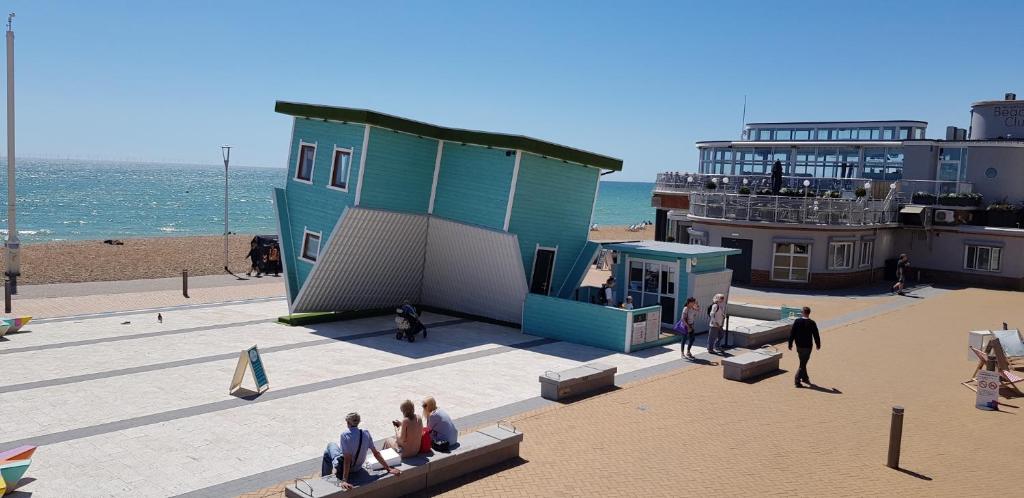 a group of people sitting around a building on the beach at Andorra Guest Accommodation in Brighton & Hove