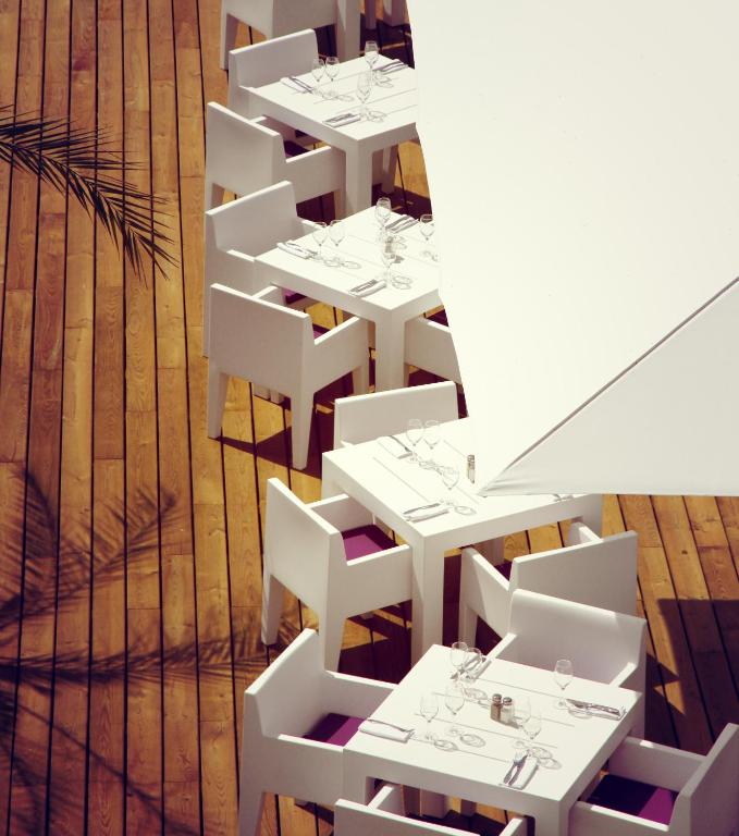 a row of white tables and chairs in a restaurant at Le Grand Hotel de la Plage in Biscarrosse-Plage