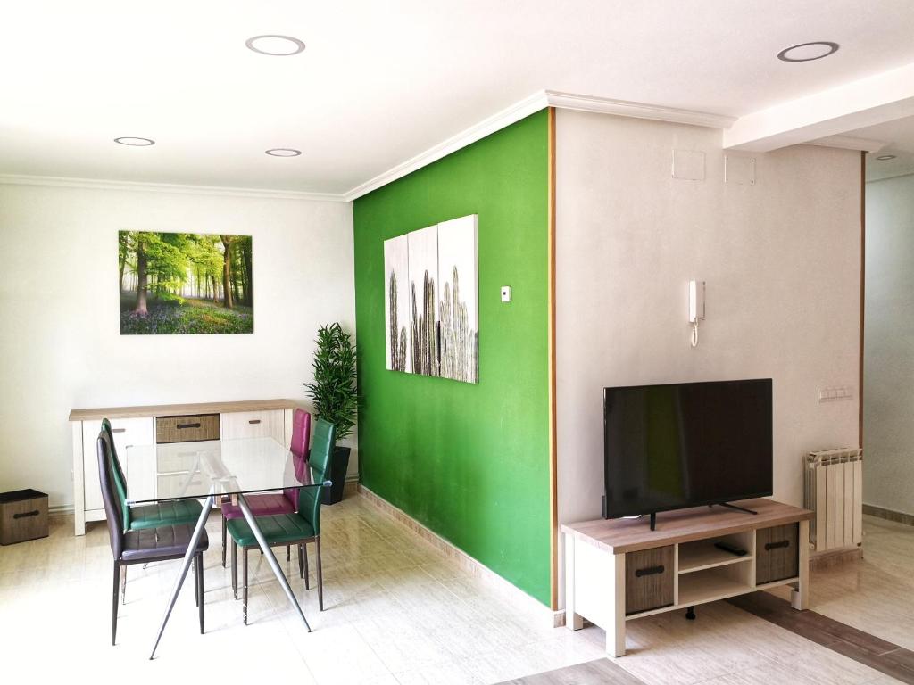 sala de estar con mesa y pared verde en Apartamentos Cocó, en Ávila