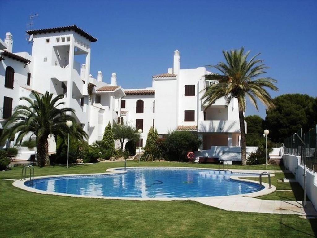 une grande maison avec une piscine en face de celle-ci dans l'établissement Residencial Parque Azahar ll, à Alcossebre