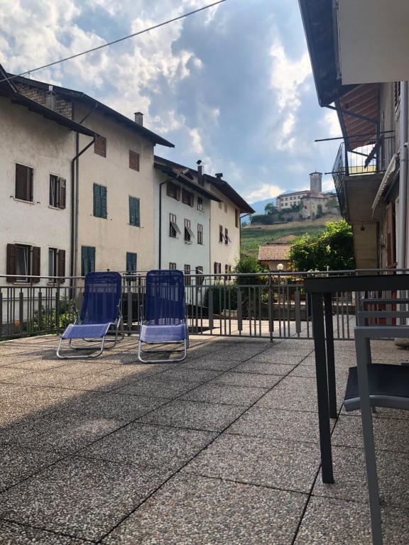Dos sillas azules sentadas en un patio con una valla en La Casa di Olivo, en Tassullo
