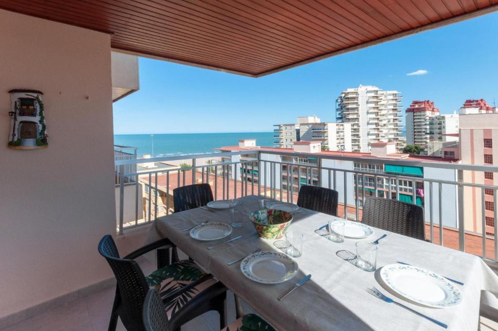 a table on a balcony with a view of the ocean at Torres Del Mar in Playa de Gandia