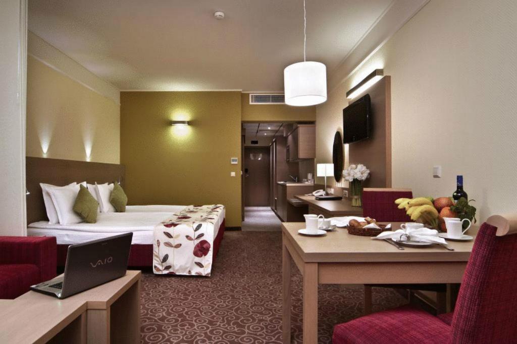 a hotel room with a bed and a table with a laptop at Flamingo Grand Hotel & Spa in Albena
