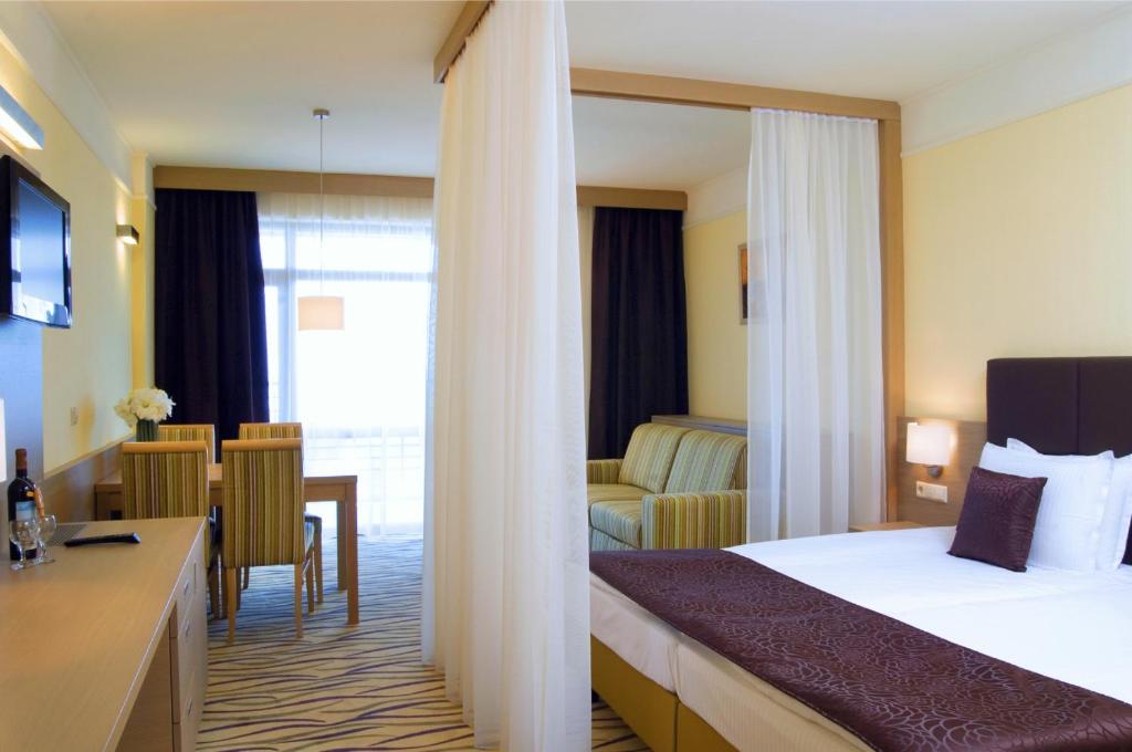 a hotel room with a bed and a table and chairs at Flamingo Grand Hotel & Spa in Albena