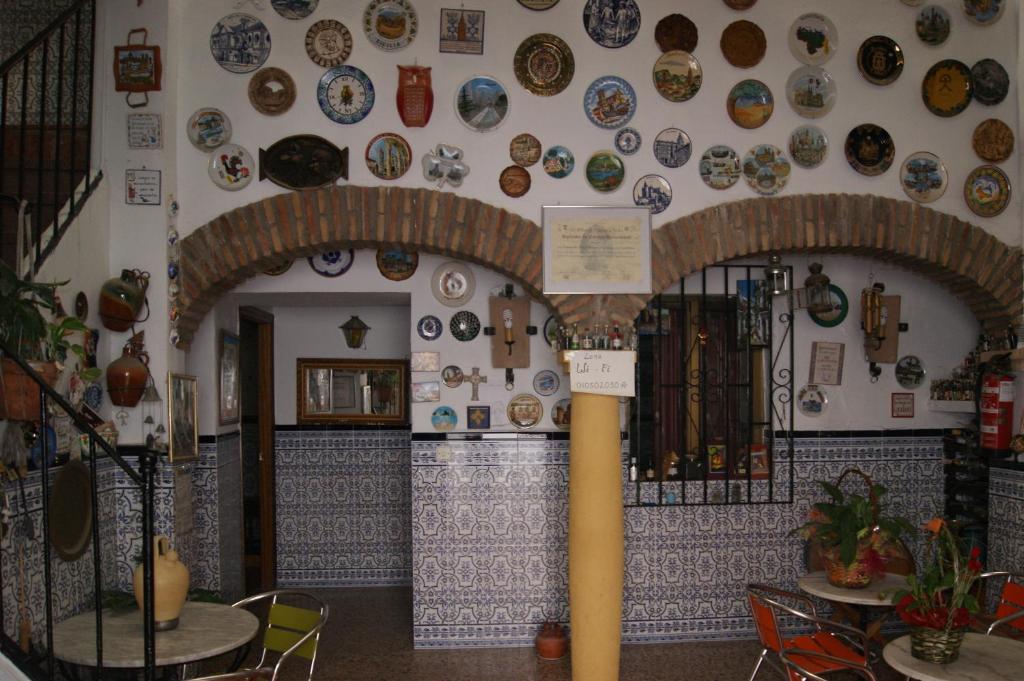 una habitación con una pared con placas en la pared en Hostal Alcázar en Córdoba