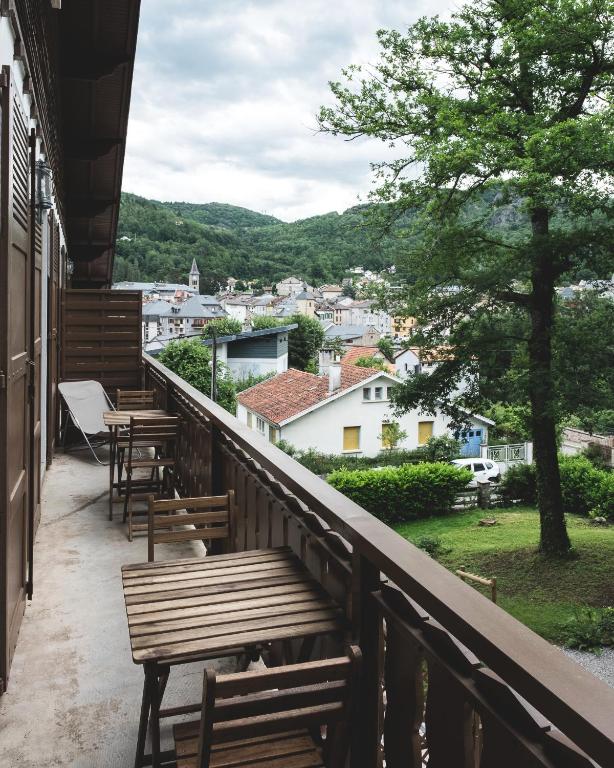 a balcony with benches and a view of a city at Au chalet des quatre saisons in Ax-les-Thermes