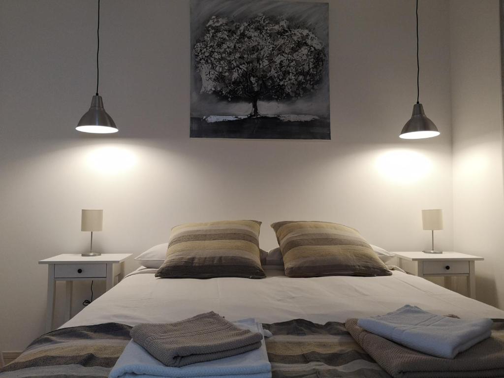 ein Schlafzimmer mit einem Bett mit zwei Nachttischen und zwei Lampen in der Unterkunft Julia apartment in Triest