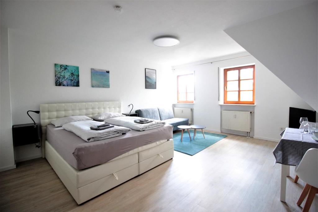 een witte slaapkamer met een bed en een woonkamer bij City Apartment - Old Main Bridge, own garage parking space in Würzburg