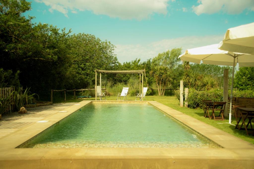 una piscina con cenador y sillas en un patio en Exus Natur - Adults Only, en Fontclara