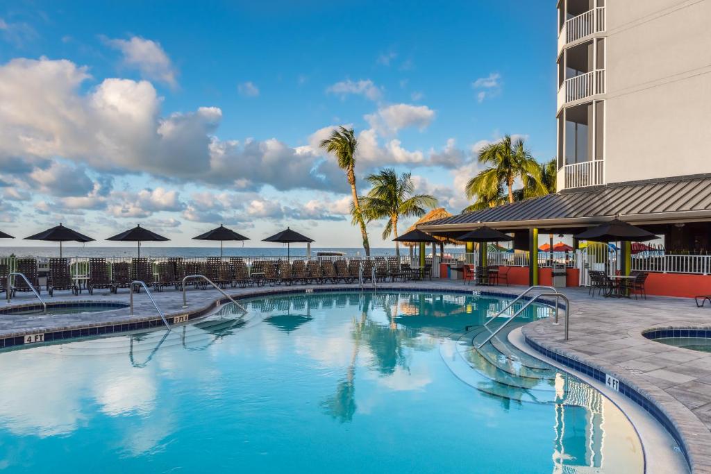 uma piscina num resort com palmeiras em Diamond Head Beach Resort em Fort Myers Beach