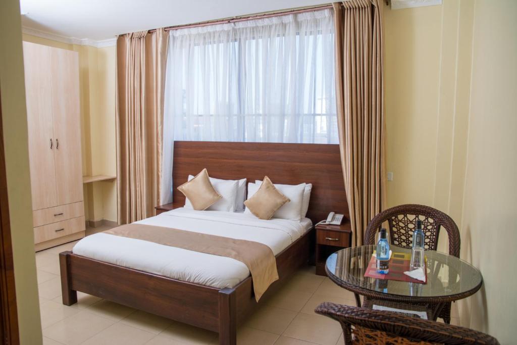 een hotelkamer met een bed en een glazen tafel bij Delfirm Hotel in Nairobi