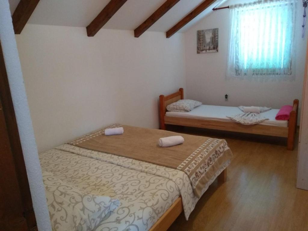 a bedroom with two beds and a window at Apartments Aida in Bihać